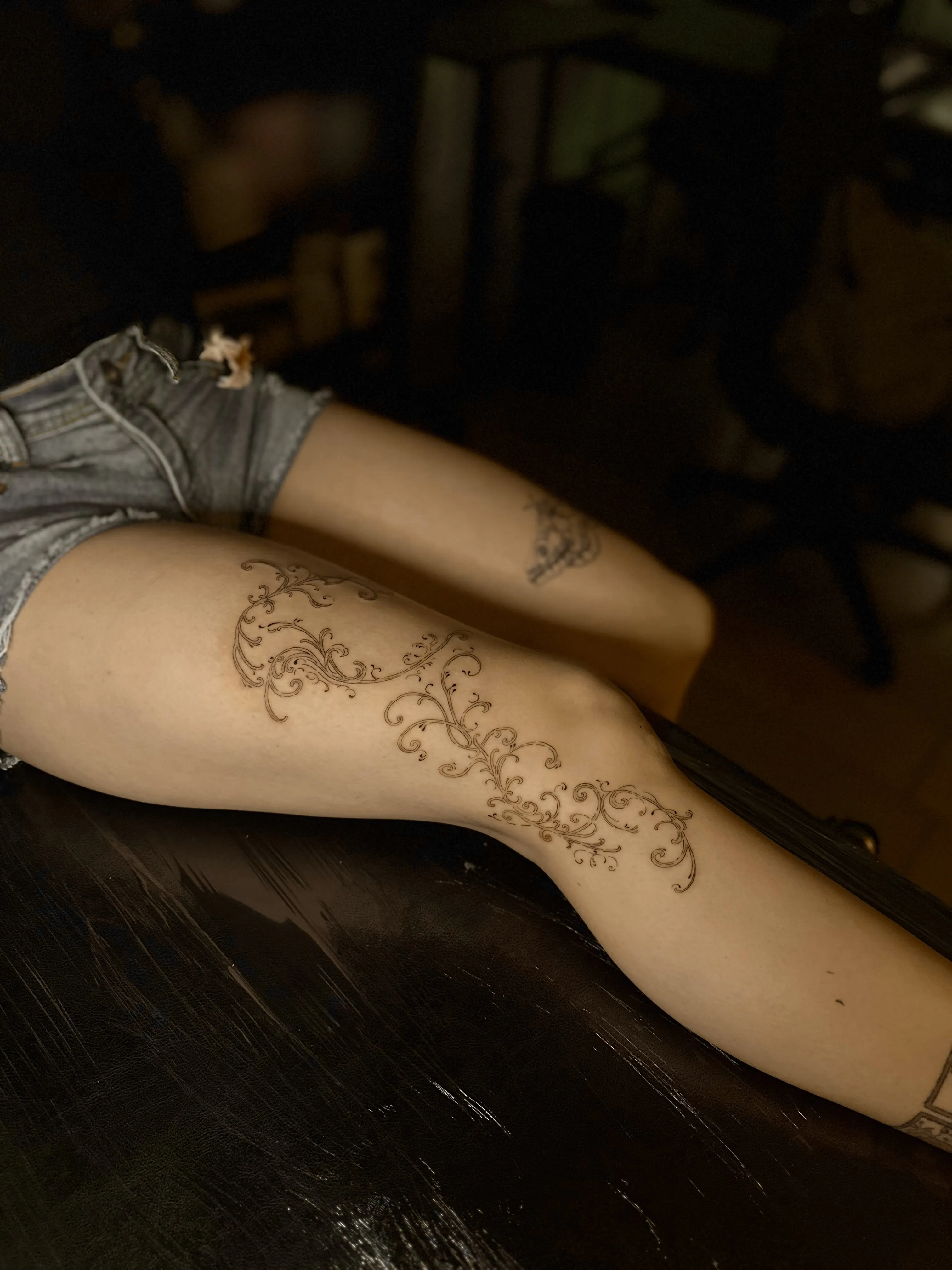 Tatuaje floral en muslo y rodilla